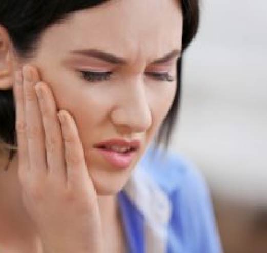 Woman Holding Side of Jaw Feeling Pain from TMJ - The Super Dentists