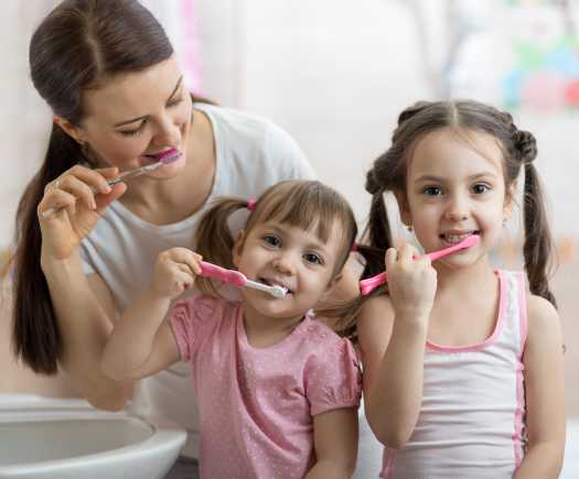 Mother and the two girls brushing teeth