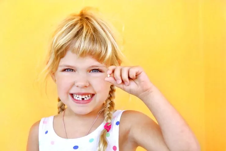 Happy young girl who lost her first tooth