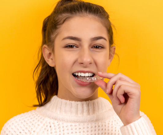 Girl adjusting aligners - The Super Dentists