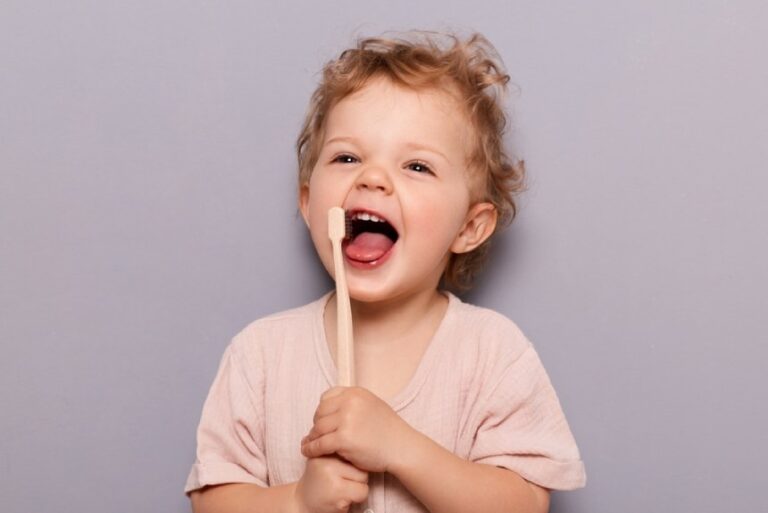 Happy baby holding a toothbrush