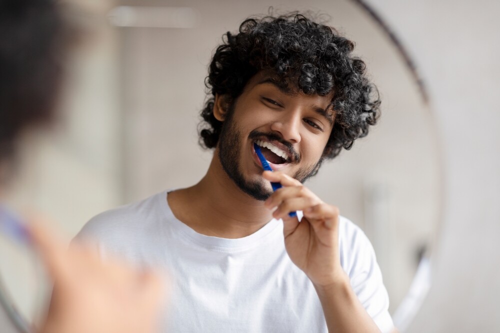 Young man brushes teeth with nano-hydroxyapatite toothpaste