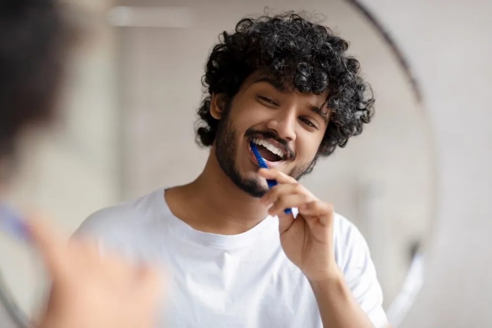 Young man brushes teeth with nano-hydroxyapatite toothpaste