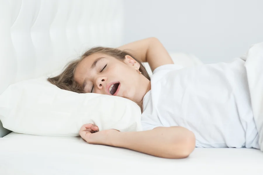 Girl sleeping in bed with mouth open