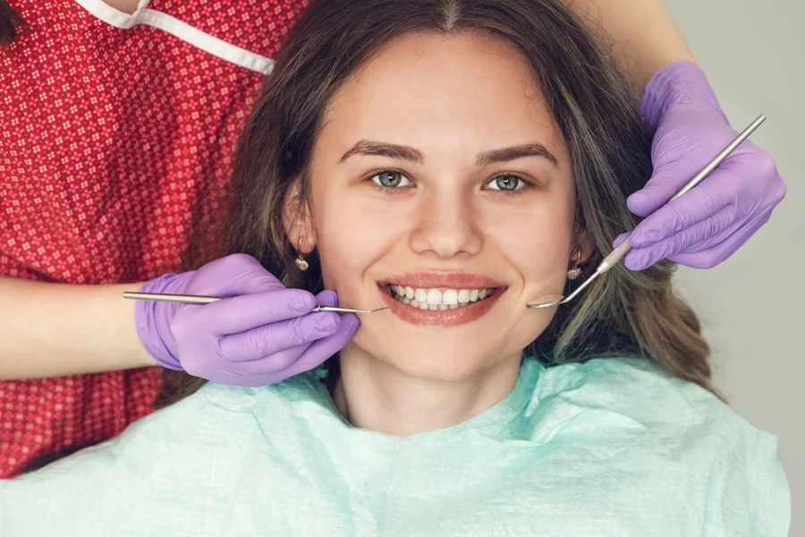 Dentist examines young teen’s teeth for signs of gingivitis