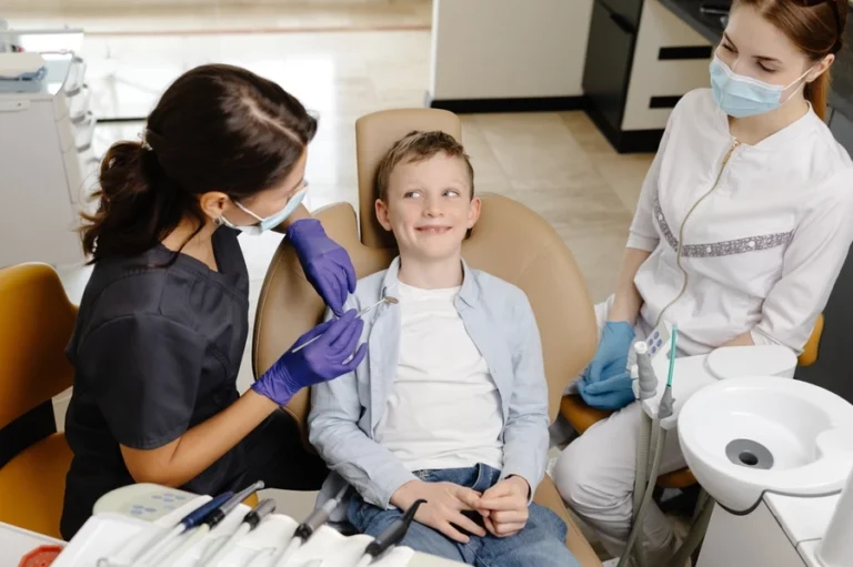 Dentist and dental hygienist prepare a young boy for a dental cleaning