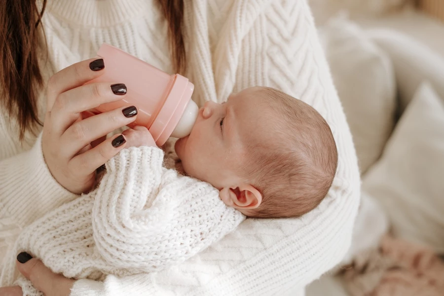 Teething baby being bottle fed