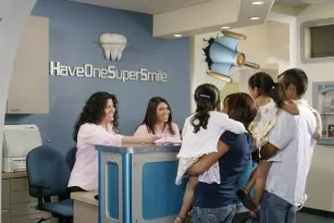 Family Checking In at Front Desk of The Super Dentists